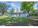 View of the backyard with an external view of the house, grass, and mature trees at 2633 Keysville Dr, Lithia, FL 33547