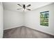 Neutrally painted bedroom with carpet and window overlooking backyard at 2633 Keysville Dr, Lithia, FL 33547