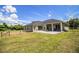 Backyard view highlighting the patio, the house's architecture, and a horse pen in the distance at 3730 Ralston Rd, Plant City, FL 33566