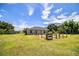 A large, grassy backyard with a wooden fence and mature shade trees at 3730 Ralston Rd, Plant City, FL 33566