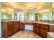 Bright bathroom featuring double sinks, wood cabinets, and a large mirror at 3730 Ralston Rd, Plant City, FL 33566