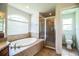 Bright bathroom featuring a soaking tub and glass-enclosed shower at 3730 Ralston Rd, Plant City, FL 33566