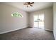 Bright bedroom with carpet, ceiling fan, arched window and sliding glass doors to the yard at 3730 Ralston Rd, Plant City, FL 33566