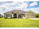 Lovely single-story home with a well-manicured lawn, arched windows, and a two-car garage at 3730 Ralston Rd, Plant City, FL 33566