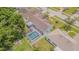 Aerial view of the home showcasing a screened-in pool, fenced yard, patio, and mature trees at 4223 Amber Ridge Ln, Valrico, FL 33594