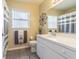 This bathroom features white cabinets, a white toilet, a plant and a window at 4223 Amber Ridge Ln, Valrico, FL 33594