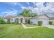 Attractive single-Gathering home with lush green lawn and meticulously maintained landscaping with mature palm tree at 4223 Amber Ridge Ln, Valrico, FL 33594