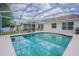 Sparkling pool with screened enclosure, complemented by a patio area for outdoor relaxation and entertaining at 4223 Amber Ridge Ln, Valrico, FL 33594
