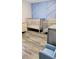 Bedroom featuring cribs, hardwood floors, and a blue accent wall at 4592 Crabapple Ave, North Port, FL 34287