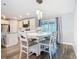 Bright dining area with white table and chairs, connecting to a modern kitchen at 4592 Crabapple Ave, North Port, FL 34287