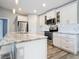 Well-lit kitchen boasts an island, stainless steel appliances, and white cabinets with glass fronts at 4592 Crabapple Ave, North Port, FL 34287