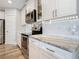 Updated kitchen features white subway tile backsplash, stainless steel appliances and granite countertops at 4592 Crabapple Ave, North Port, FL 34287