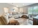 Inviting living room featuring a cozy sectional couch, wood-look floors, and natural light at 4592 Crabapple Ave, North Port, FL 34287