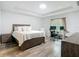 Main bedroom with tray ceilings, wood floors, and a dedicated workspace by the window at 4592 Crabapple Ave, North Port, FL 34287