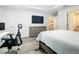 This main bedroom features a TV over a dresser and an office space with a desk and chair at 4592 Crabapple Ave, North Port, FL 34287