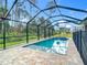 Screened in pool and jacuzzi with a brick surround and views of the private yard at 4592 Crabapple Ave, North Port, FL 34287