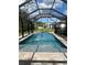 Backyard screened-in pool with adjacent spa offers a luxurious outdoor experience at 4592 Crabapple Ave, North Port, FL 34287