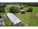 Aerial view of a home on a sprawling lawn, featuring mature trees, a barn, and fenced border at 4611 Executive Meadows Dr, Plant City, FL 33567