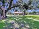 Expansive backyard with mature trees, lush green grass, and an enclosed patio, ideal for outdoor gatherings at 4611 Executive Meadows Dr, Plant City, FL 33567