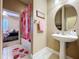 Cozy bathroom area includes pedestal sink, strawberry-themed shower curtain and round mirror at 4611 Executive Meadows Dr, Plant City, FL 33567