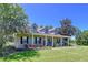 Inviting home with a wide porch, dark shutters, and landscaped garden, creating a welcoming curb appeal at 4611 Executive Meadows Dr, Plant City, FL 33567