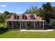 Attractive home with a covered porch, dark shutters, and landscaped garden, creating a welcoming curb appeal at 4611 Executive Meadows Dr, Plant City, FL 33567