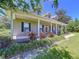 Close up of an inviting porch, featuring classic rocking chairs, black shutters, and colorful flowers at 4611 Executive Meadows Dr, Plant City, FL 33567