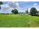 Spacious back yard with manicured lawn and inviting seating area complete with umbrella and outdoor furniture at 4616 Edwards Rd, Plant City, FL 33567
