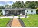Well-maintained backyard with a charming sunroom, outdoor seating, and lush green lawn at 4616 Edwards Rd, Plant City, FL 33567