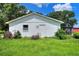 Side exterior view of a home with a well maintained lawn, small garden, and a peek at the screened lanai at 4616 Edwards Rd, Plant City, FL 33567