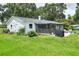 Back exterior view of a well-maintained house with a screened lanai and a spacious backyard at 4616 Edwards Rd, Plant City, FL 33567