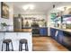 Charming kitchen featuring blue cabinets, open shelving, stainless steel appliances, and a breakfast bar at 4616 Edwards Rd, Plant City, FL 33567