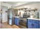 Stylish kitchen with blue cabinets, stainless steel refrigerator, and open shelving for decor and storage at 4616 Edwards Rd, Plant City, FL 33567