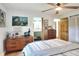 Stylish main bedroom with ensuite bathroom, wood dresser, and ceiling fan at 4616 Edwards Rd, Plant City, FL 33567