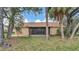View of the backyard featuring a screened-in patio and natural landscaping at 8050 Eacon Ct, Hudson, FL 34667