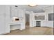 Bright kitchen with modern white cabinetry, stone countertops, and stylish wood-look floors at 8050 Eacon Ct, Hudson, FL 34667