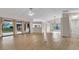 Spacious living room with wood-look floors, neutral walls, and sliding glass doors to the backyard at 8050 Eacon Ct, Hudson, FL 34667