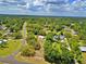 Expansive aerial view of a home nestled among lush greenery and trees, under a partly cloudy sky at 12410 Myrtlewood Dr, Riverview, FL 33579