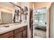 Bathroom with a dark wood vanity, double sinks, and open to the bedroom at 32668 Abby Lax Ln, Wesley Chapel, FL 33543