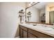 Bathroom with double sinks, dark wood cabinetry and decor shelves at 32668 Abby Lax Ln, Wesley Chapel, FL 33543