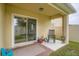 Cozy covered patio with sliding glass doors, rocking chair and decorative outdoor rug at 32668 Abby Lax Ln, Wesley Chapel, FL 33543
