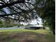 Spacious backyard with mature trees and a screened-in pool area, perfect for outdoor activities and relaxation at 37341 Rutledge Dr, Zephyrhills, FL 33541