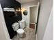 Stylish bathroom with black accent wall, modern sink, round mirror, and decorative shelving at 37341 Rutledge Dr, Zephyrhills, FL 33541