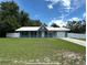 Charming single story home with a well-manicured lawn, white fence, and covered entryway at 37341 Rutledge Dr, Zephyrhills, FL 33541