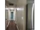 Hallway with hardwood floors, white walls and doors, stainless steel refrigerator at 37341 Rutledge Dr, Zephyrhills, FL 33541