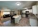 Modern kitchen with white cabinets and stainless steel appliances adjacent to living room at 37341 Rutledge Dr, Zephyrhills, FL 33541