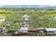 Aerial view of home with lush trees, backyard deck, waterfront dock, boat lift and boat at 9934 Peninsular Dr, Gibsonton, FL 33534