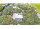 Aerial view of home surrounded by trees, with backyard deck, dock, and river access at 9934 Peninsular Dr, Gibsonton, FL 33534