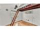 Cozy bedroom with hardwood floors, window, and unique loft access ladder at 9934 Peninsular Dr, Gibsonton, FL 33534