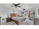 Bedroom with white paneled walls, two ceiling fans, and a wooden bed frame on top of a patterned rug at 9934 Peninsular Dr, Gibsonton, FL 33534